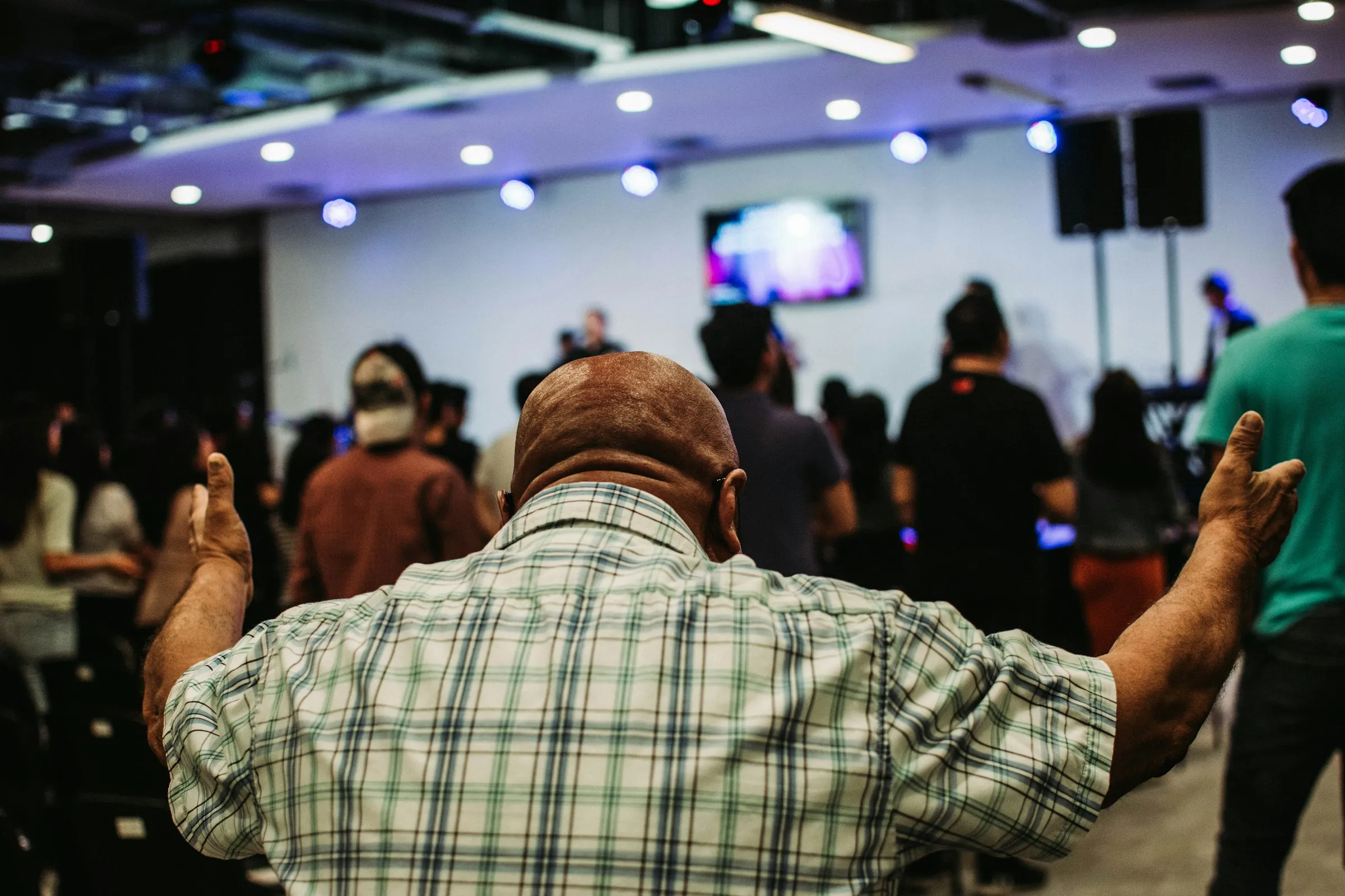 People gathered in a bright room, listening.
